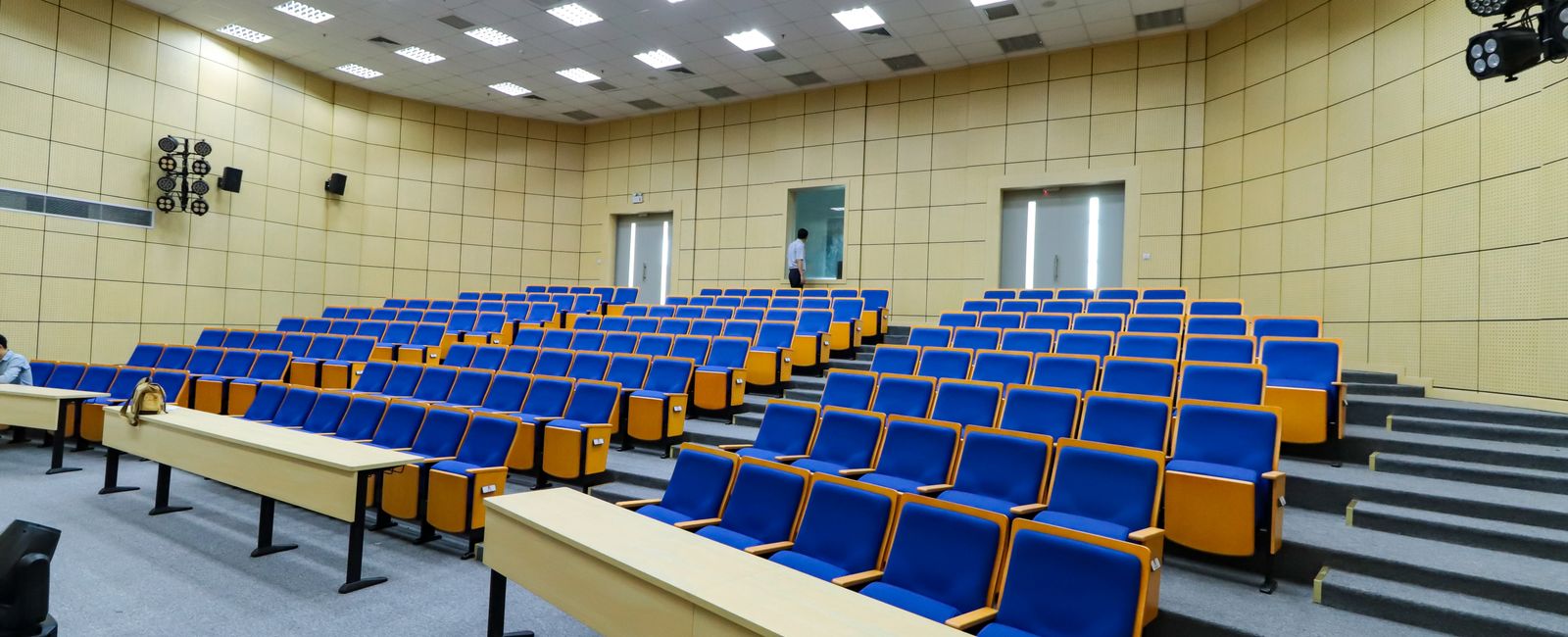 Empty lecture hall with rows of blue seats